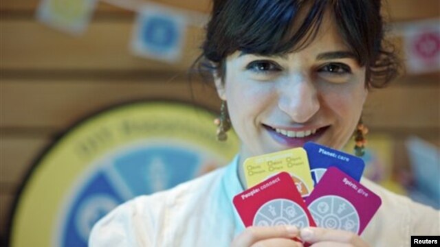 Joanna Choukeir shows some of the cards from a DIY Happiness card game, at the launch of  'Action For Happiness' encouraging meditation, hugging and kindness, in London, April 12, 2011.