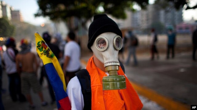 Người biểu tình chống chính phủ đeo mặt nạ trong cuộc đụng độ với cảnh sát tại Caracas, Venezuela. 