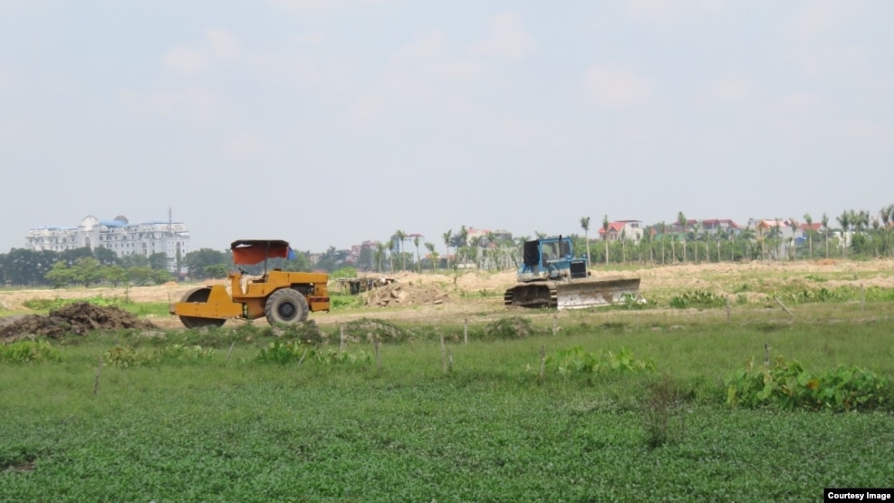 Ruộng đất của dân chưa đền bù xong nhưng các phương tiện thi công của chủ dự án vẫn ngang nhiên tiến hành san lấp. (Ảnh: Lê Anh Hùng)