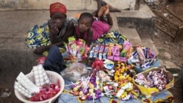  Girls selling sweets watch from their makeshift kiosk - as other boys and girls their age [not pictured] attend school - amid great poverty, in the city of Makeni in Sierra Leone, April 20, 2012.