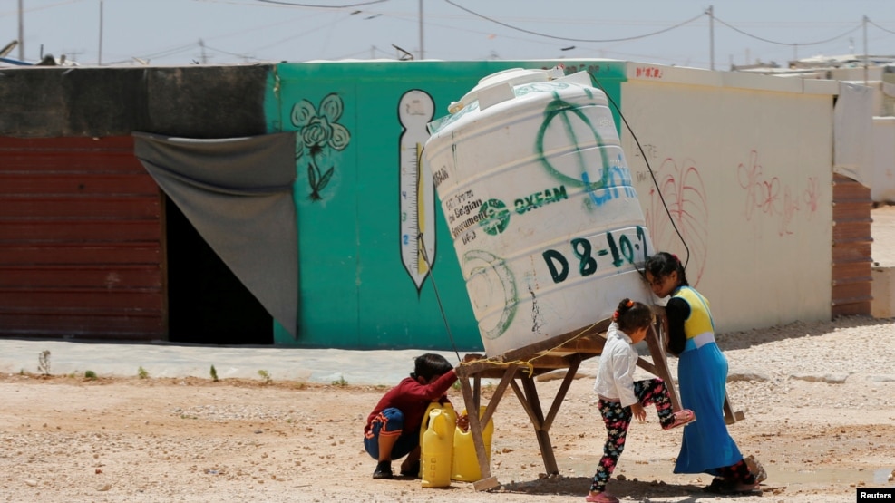 Syrian refugees children collect water at the Al-Zaatari refugee camp in Mafraq, Jordan, near the border with Syria, May 30, 2016.