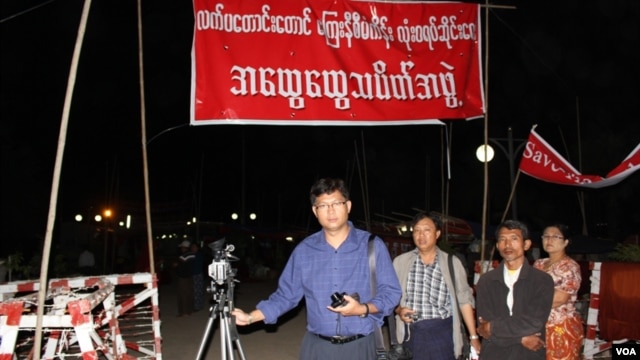 လက္ပန္းေတာင္းေတာင္ ေၾကးနီစီမံကိန္းရပ္တန္႔ေရး သပိတ္စခန္းရွိရာ ဝမ္ေပါင္ကုမၸဏီေရွ႕မွာ သတင္းယူေနတဲ့ ဗီြအိုေအ ျမန္မာပိုင္း သတင္းေထာက္ ကိုသိန္းထိုက္ဦး။ (ႏိုဝင္ဘာ ၂၈၊ ၂၀၁၂)။ 