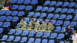 Soldiers sit in the empty seats held by the IOC as they watch the women's gymnastics qualification in the North Greenwich Arena during the London 2012 Olympic Games July 29, 2012.