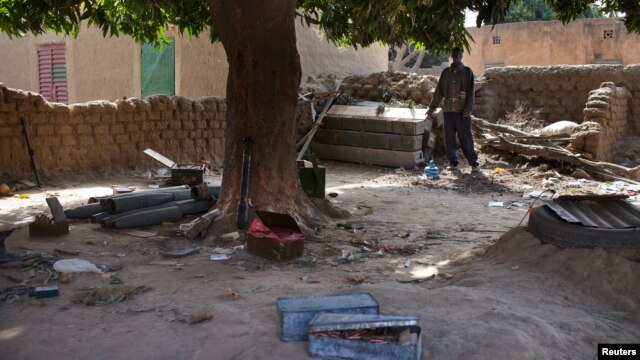  Local resident Issa Dembele stands next to munitions, believed to belong to Islamist rebels, stockpiled in the courtyard of his house in Diabaly, Mali, Jan. 23, 2013.