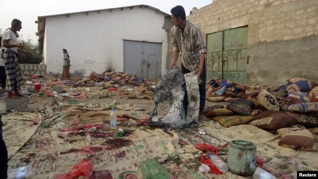 A man holds burnt garments at the site of a suicide bombing in Yemen's southern city of Jaar August 5, 2012.