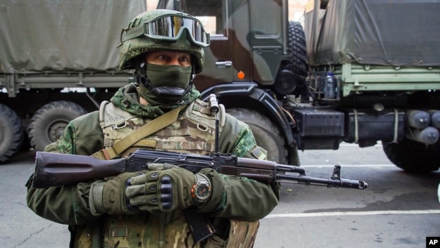 FILE - A pro-Russia rebel stands guard during preparations for a prisoner exchange in Donetsk, eastern Ukraine, Oct. 29, 2015.