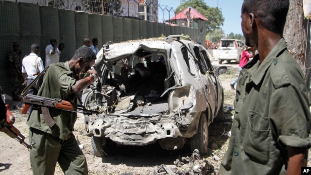 FILE - Security forces inspect the scene of a car bomb attack in the capital Mogadishu, Somalia, April 11, 2016. A car bomb exploded outside a restaurant packed with lunchtime customers, killing at least five people according to witnesses.