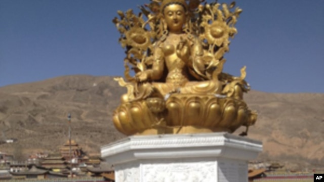 Sonam Dargye's body, covered in ceremonial scarves called katha, can be seen at the foot of the golden statue at Rongwo Temple.