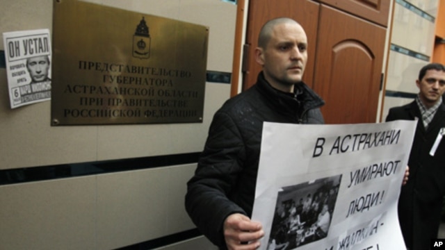 Russian opposition leader Sergei Udaltsov holds a placard during a rally outside the representative offices of the Astrakhan region during a rally in Moscow,  April 9, 2012. 
