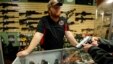 FILE - A gun store employee speaks to a customer about the purchase of a 9mm handgun in Bridgeton, Missouri, Nov. 13, 2014.