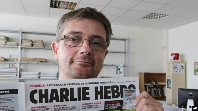 Izdavač satiričnog nedeljnika Charlie Hebdo pozira fotografima sa naslovnom stranicom svog časopisa u Parizu, 19. septembra 2012. 