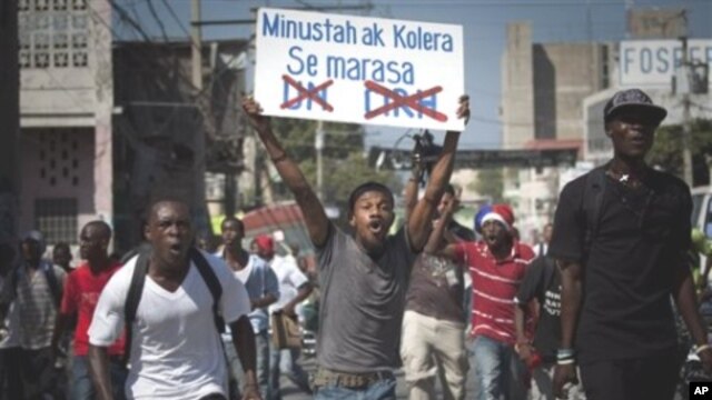 A demonstrator shouts as he carries a sign reading in Creole 'Minusta and Cholera are twins' during a protest in Port-au-Prince, Haiti, 18 Nov 2010