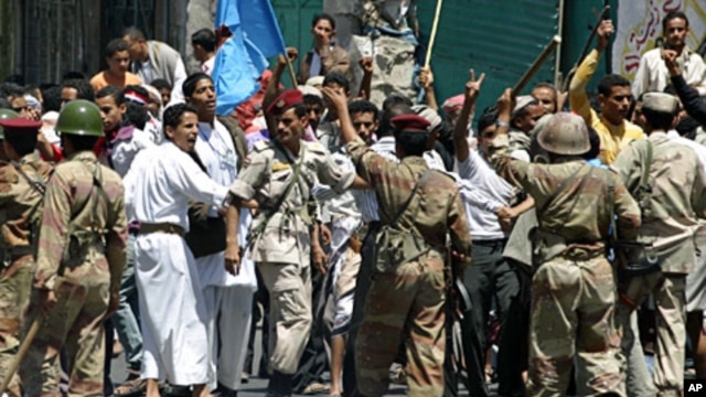 Soldiers hold back supporters of Yemen's President Ali Abdullah Saleh during clashes with anti-government protesters in the southern city of Taiz, Apr 22 2011