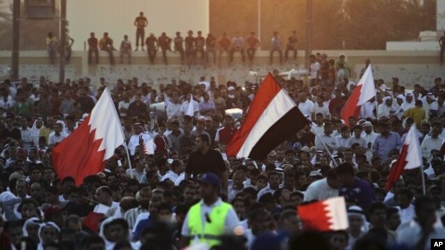 Supporters of the Shiite opposition Al-Wefaq society wave red-and-white Bahraini flags and a Yemeni flag during a rally in Tubli, Bahrain, near the capital of Manama, September 22, 2011.