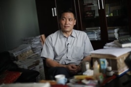 中国人权律师浦志强2009年在便衣警察监视下对记者发表谈话