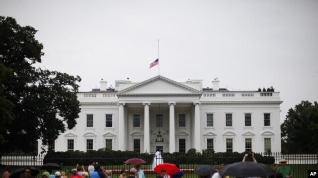 The American flag is seen at half-staff over the White House in Washington, July 20, 2012. 