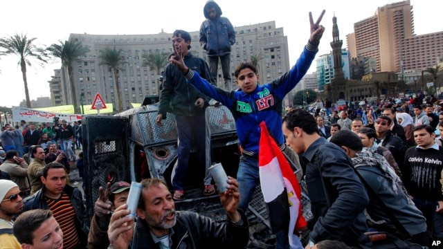 Egyptian protesters celebrate the capture of a state security armored vehicle that demonstrators commandeered during clashes with security forces and brought to Tahrir Square in Cairo, January 29, 2013. 