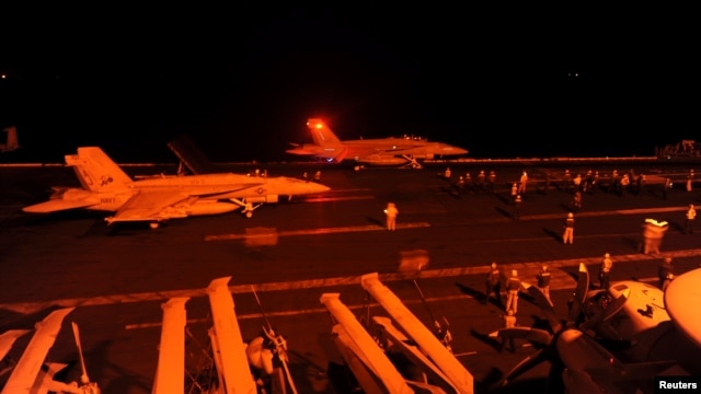 Chiến đấu cơ F/A-18 Super Hornet chuẩn bị cất cánh từ boong tàu bay của tàu sân bay USS George HW Bush (CVN 77) để thực hiện nhiệm vụ tấn công các mục tiêu IS ở Syria.