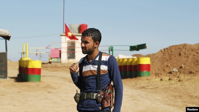 An officer of the Syrian Kurdish Democratic Union Party (PYD) stands guard near the Syrian-Iraq border, October 31, 2012.