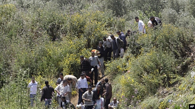 Syrians cross the border into Lebanon as they flee the violence in the Syrian village of Talkalakh, in the Wadi Khaled area, about one kilometer (0.6 miles) from the Lebanon-Syria border, north of Lebanon, May 16, 2011