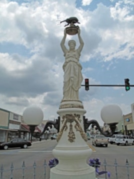 A statue on Main Street in Enterprise, Alabama, features a woman holding a large, black boll weevil above her head.