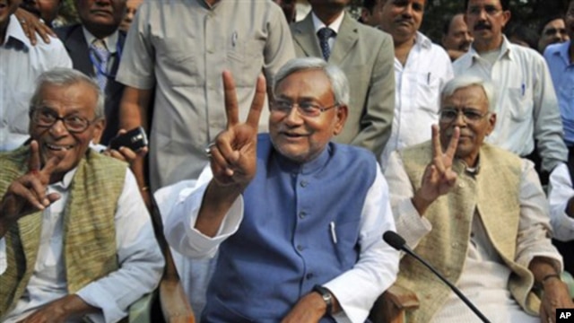 Bihar state Chief Minister Nitish Kumar, center, displays the victory sign during a press conference after his National Democratic Alliance won the state elections, in Patna, India, Nov. 24, 2010. Kumar, the top elected official of one of India's poorest 
