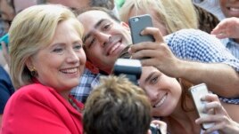 Democratic presidential candidate Hillary Rodham Clinton poses for a photo with two of her supporters on the campus of Case Western Reserve University in Cleveland.