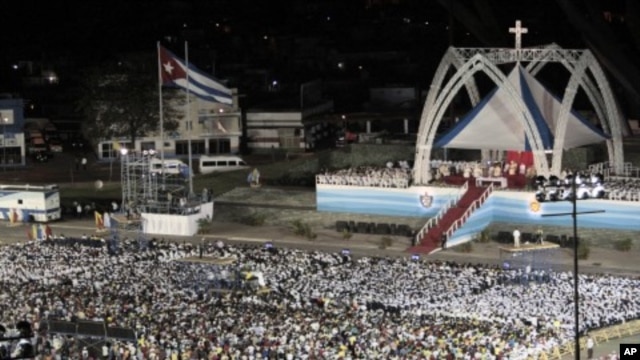 People attend a mass celebrated by Pope Benedict XVI in Antonio Maceo square in Santiago, Cuba, March 26, 2012.
