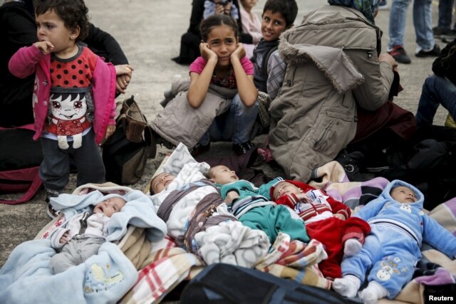 FILE - Five Syrian babies, three of them triplets, lie on blankets among relatives following the arrival of migrants from the islands of Lesbos and Chios at the port of Piraeus, near Athens, Greece, Oct. 21, 2015.