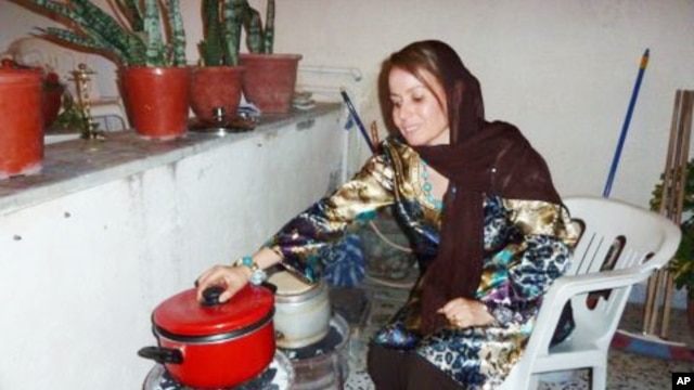 In the garage of her Tripoli house, Fatma Ghobtan checks a pot on a charcoal stove she fashioned from two car wheels after gas was cut off.