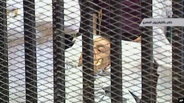 Former Egyptian President Hosni Mubarak is wheeled into a holding cell in the court room in the police academy on the outskirt of the capital Cairo, where he faces murder charges, August 3, 2011