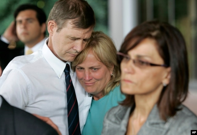 FILE - Andrew Goddard, whose son was wounded during a deadly 2007 shooting at Virginia Tech in 2007, comforts another parent during a 2008 news conference announcing an $11 million state settlement with victims’ families.