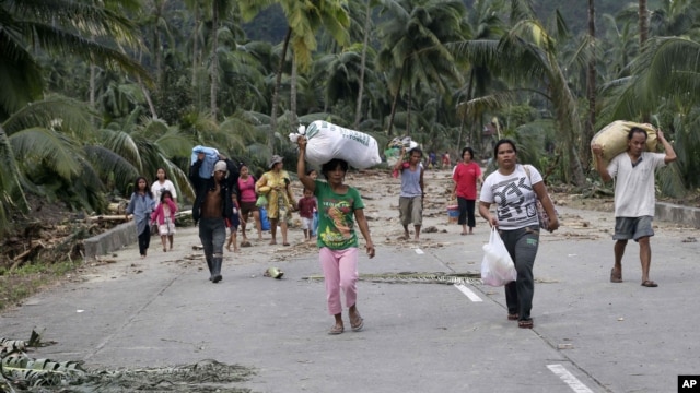 Residents evacuate to higher grounds at the flash flood-hit village of Andap, New Bataan township, Compostela Valley in southern Philippines, December 5, 2012.