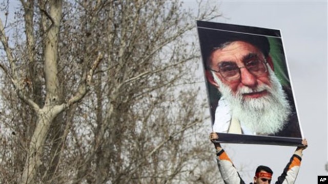 A pro-government Iranian holds a poster of supreme leader Ayatollah Ali Khamenei during the funeral ceremony of Sane Jaleh, a student who was killed during Monday's clashes, in Tehran, Iran, February 16, 2011