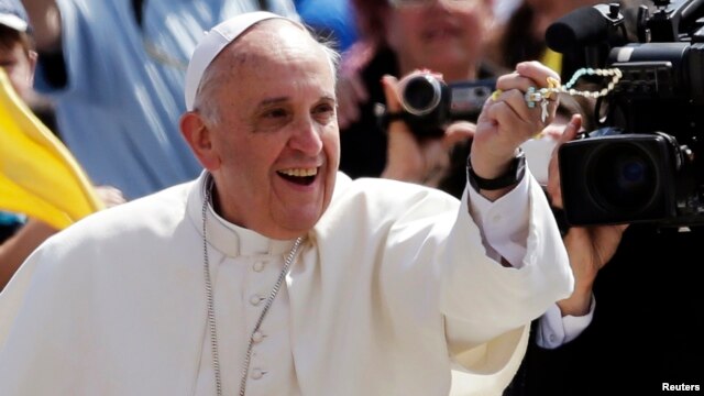 Pope Francis catches a rosary thrown by faithful as he arrives to lead his Wednesday general audience in Saint Peter's Square at the Vatican, June 5, 2013. 