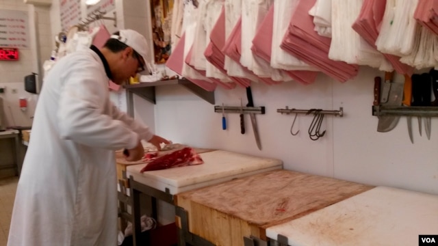 Meat is being prepared at Boucherie de l'Argonne, in Paris, Feb. 3, 2016. (L. Bryant/VOA)