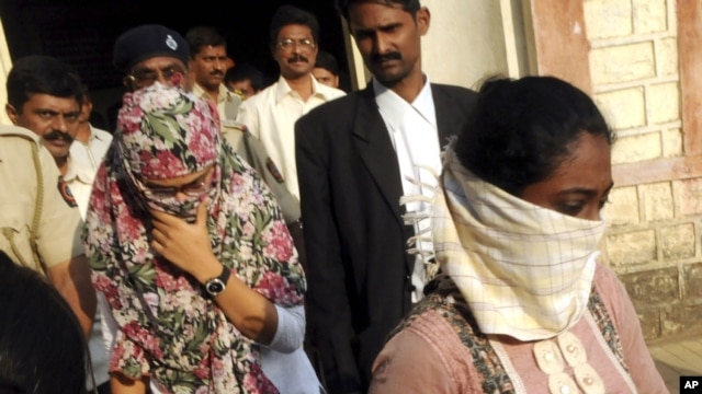 Face covered Shaheen Dhada, left, and Renu Srinivas, come out of a court in Mumbai, India after being arrested for their Facebook post, November 20, 2012.