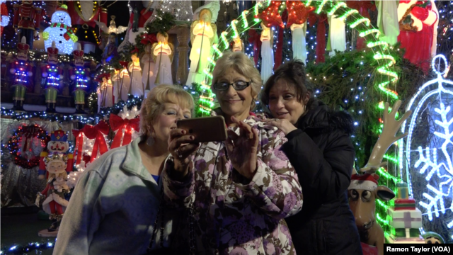 Suzanne Lechnos, center, is a regular at the holiday light display in Dyker Heights, New York.