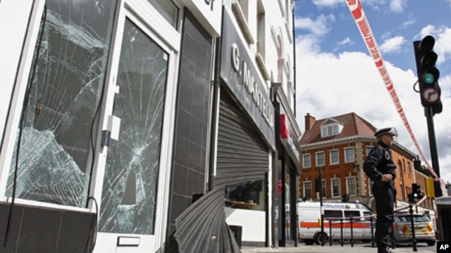 Smashed glass doors and windows and wrecked shutters of a betting shop and a jewelry shop in Enfield, north London,  Aug. 8, 2011