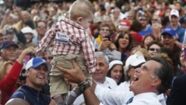 Republican presidential nominee Mitt Romney holds a baby up in the air after a campaign rally at the Golden Lamb in Lebanon, Ohio October 13, 2012.