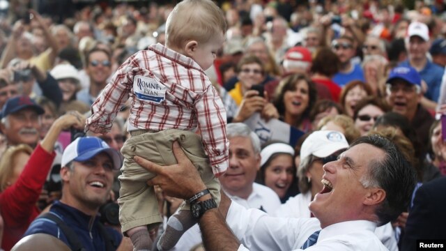 Republican presidential nominee Mitt Romney holds a baby up in the air after a campaign rally at the Golden Lamb in Lebanon, Ohio October 13, 2012.