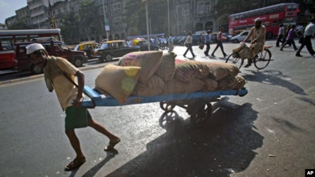 A man pulls a hand-drawn cart loaded with sacks of chickpeas on a main road in Mumbai,  April 21, 2011
