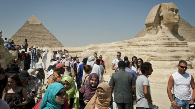 In this September 27, 2012 photo, foreign tourists visit the historical site of the Giza Pyramids, near Cairo, Egypt.