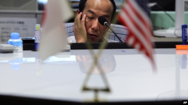 A money trader waits for calls from clients during the morning trading at a money brokerage in Tokyo Monday, Aug. 8, 2011.