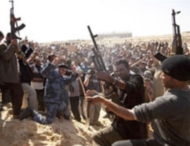 Libyan gunmen from the forces against Libyan leader Moammar Gadhafi fire in the air during a mass funeral for rebel gunmen killed in fighting in Ajdabiya, eastern Libya, March 3, 2011