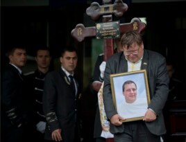 A mourner carries the picture of regional parliament member Vyacheslav Markin, in Odessa, Ukraine, May 5, 2014. Markin, who was known for speaking out against the government in Kyiv.