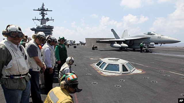 Philippine President Benigno Aquino III (2nd L) watches an F/A-18 Hornet fighter jet about to be catapulted from the US Navy's USS Carl Vinson aircraft carrier near the Philippines, May 14, 2011