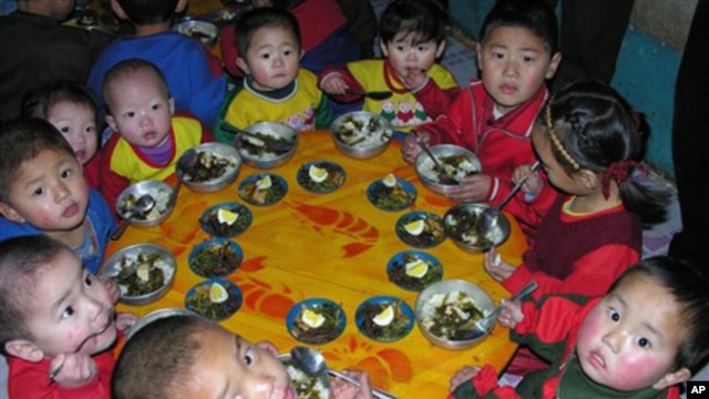 In this photo released by the World Food Program, North Korean children eat a lunch, including rice provided by the U.N. World Food Program.