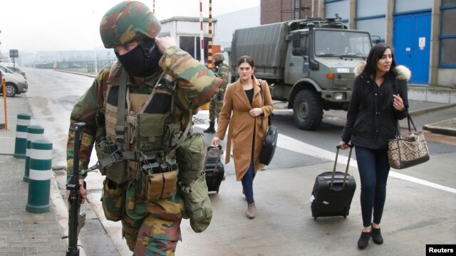 A Belgian soldier accompanies passengers at  Brussels' Zaventem airport  following Tuesday's bomb attacks in Brussels, Belgium, March 23, 2016. 