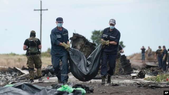 Nhân viên cấp cứu Ukraina khiêng túi chứa thi thể nạn nhân ra khỏi địa điểm vụ tai nạn gần làng Hrabove, miền đông Ukraine, ngày 20/7/2014.